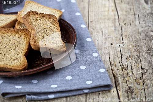 Image of Toasted cereal bread slices on brown ceramic plate closeup on li