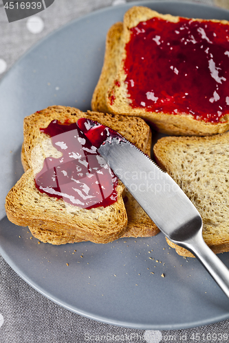 Image of Fresh toasted cereal bread slices with homemade cherry jam and k