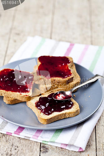 Image of Fresh toasted cereal bread slices with homemade cherry jam and s