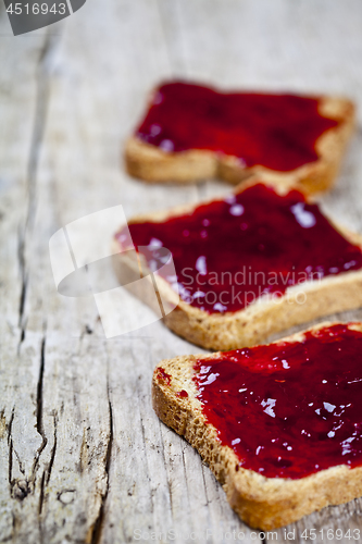 Image of Fresh toasted cereal bread slices with homemade cherry jam close