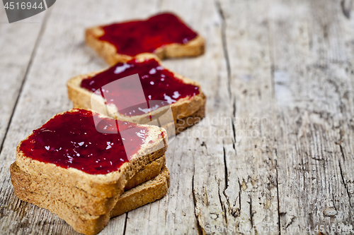 Image of Toasted cereal bread slices with homemade cherry jam closeup on 