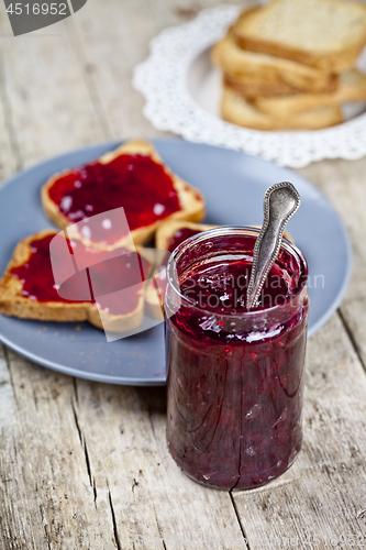 Image of Homemade cherry jam and fresh toasted cereal bread slices plates