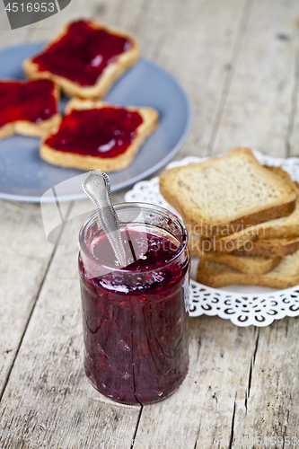 Image of Homemade cherry jam and fresh toasted cereal bread slices plates