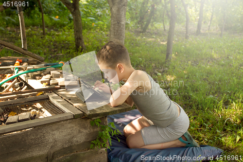 Image of Boy playing on tablet