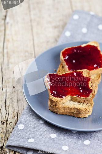 Image of Fresh toasted cereal bread slices with homemade cherry jam on gr