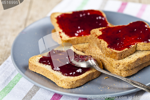 Image of Fresh toasted cereal bread slices with homemade cherry jam and s