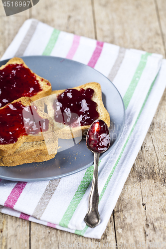 Image of Fresh toasted cereal bread slices with homemade cherry jam and s