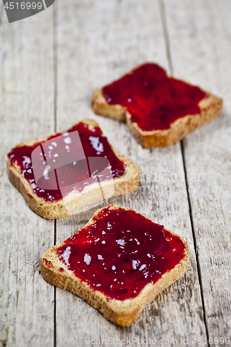Image of Toasted cereal bread slices with homemade cherry jam closeup on 