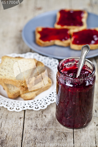 Image of Homemade cherry jam and fresh toasted cereal bread slices plates