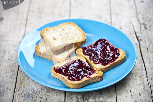 Image of Fresh toasted cereal bread slices with homemade wild berries jam