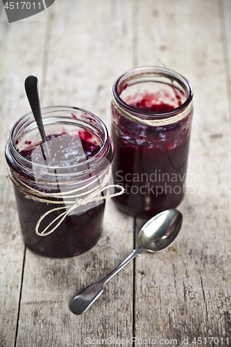 Image of Two jars of fresh cherry and wild berries  homemade jam in jar o