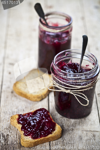 Image of Toasted cereal bread slices and jars with homemade wild berries 