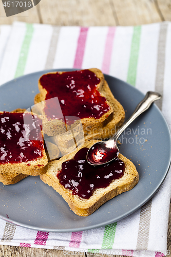 Image of Fresh toasted cereal bread slices with homemade cherry jam and s
