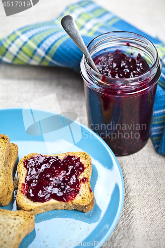 Image of Toasted cereal bread slices on blue ceramic plate and homemade w