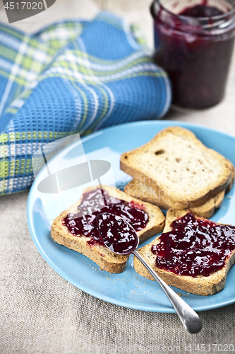 Image of Toasted cereal bread slices on blue ceramic plate and homemade w