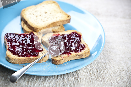 Image of Fresh toasted cereal bread slices with homemade wild berries jam