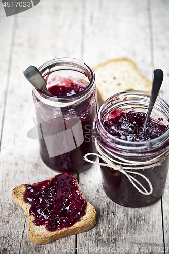 Image of Cereal bread toasts slices and jars with homemade wild berries a