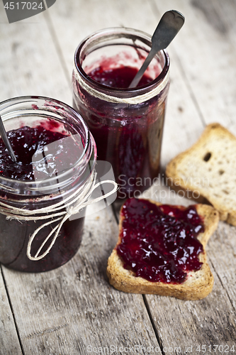 Image of Toasted cereal bread slices and jars with homemade wild berries 