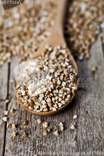 Image of Organic green dry buckwheat seads in wooden spoon closeup on rus