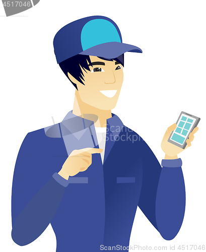 Image of Young asian mechanic holding a mobile phone.