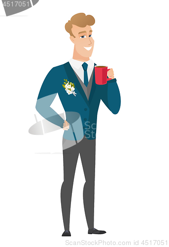 Image of Young caucasian groom holding cup of coffee.