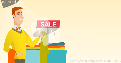 Image of Young man choosing clothes in the shop on sale.