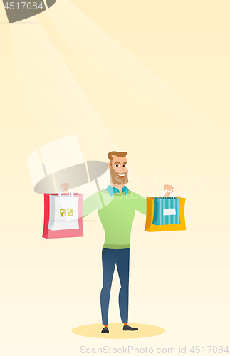 Image of Young caucasian man holding shopping bags.