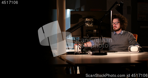 Image of man working on computer in dark office