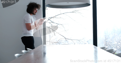 Image of young man using a tablet at home