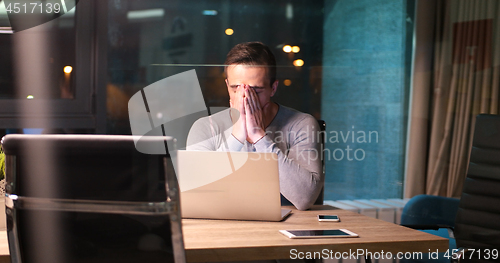 Image of man working on laptop in dark office