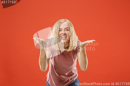 Image of Beautiful female half-length portrait isolated on red studio backgroud. The young emotional surprised woman