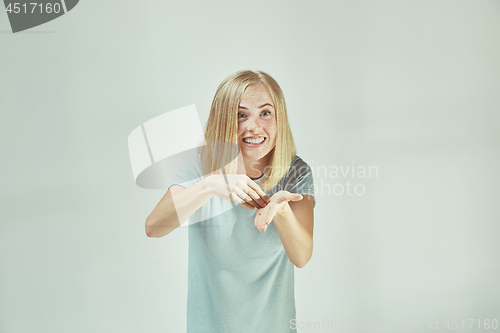 Image of Beautiful female half-length portrait isolated on gray studio backgroud. The young emotional surprised woman