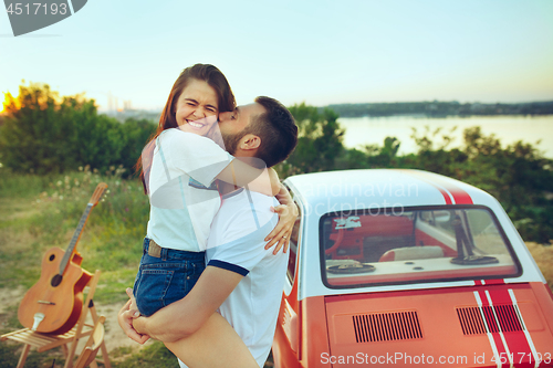 Image of Couple sitting and resting on the beach on a summer day near river