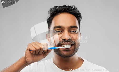 Image of indian man with toothbrush cleaning teeth