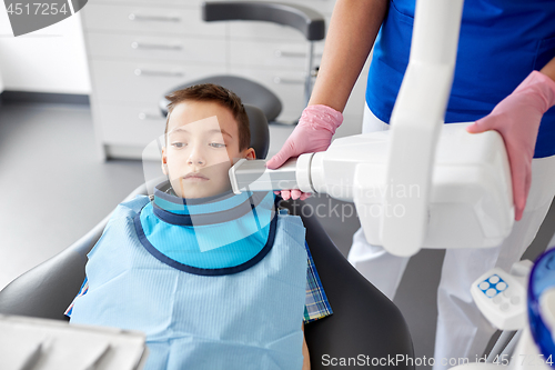 Image of dentist making x-ray of kid teeth at dental clinic