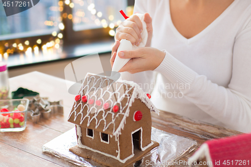 Image of woman making gingerbread houses on christmas