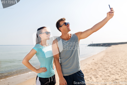 Image of couple taking selfie by smartphone on beach