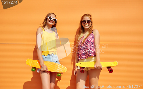 Image of teenage girls with short skateboards outdoors