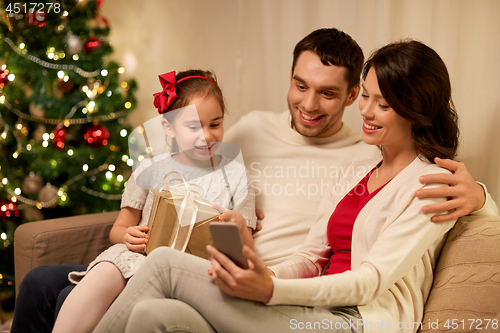 Image of family with smartphone at home on christmas