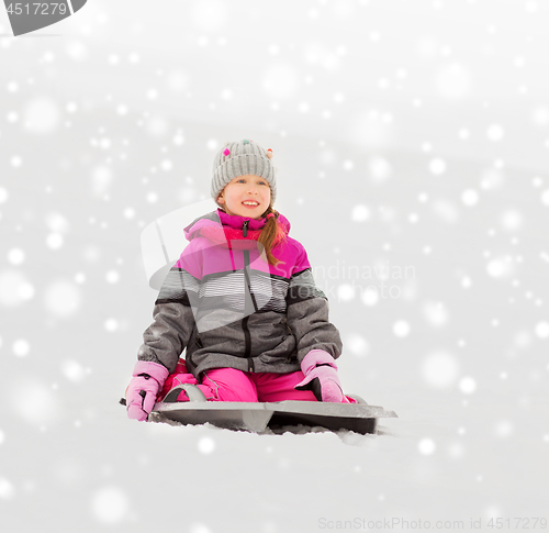 Image of happy little girl on sled outdoors in winter