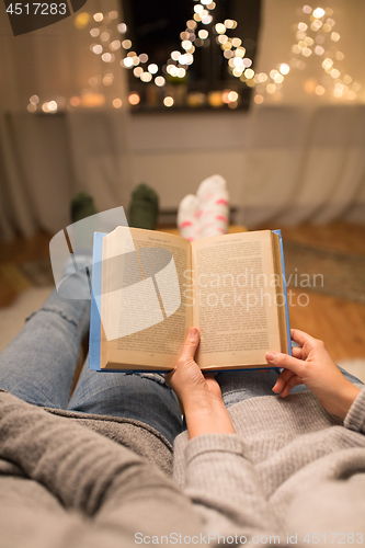 Image of close up of couple reading book at home