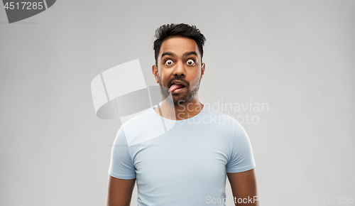 Image of indian man making faces and showing his tongue
