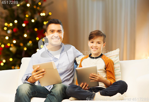 Image of father and son with tablet computers on christmas