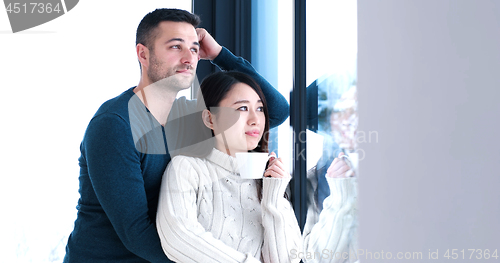 Image of multiethnic couple relaxing at modern home indoors