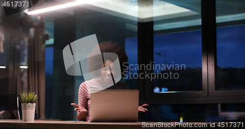 Image of black businesswoman using a laptop in night startup office