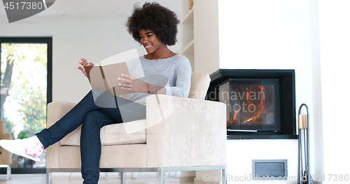 Image of black woman at home reading book