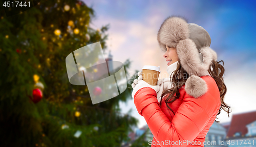 Image of woman with coffee over christmas tree in tallinn