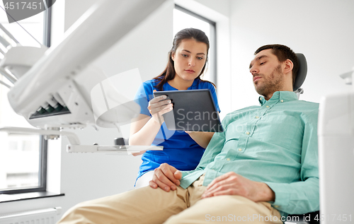 Image of dentist and patient with tablet pc at clinic