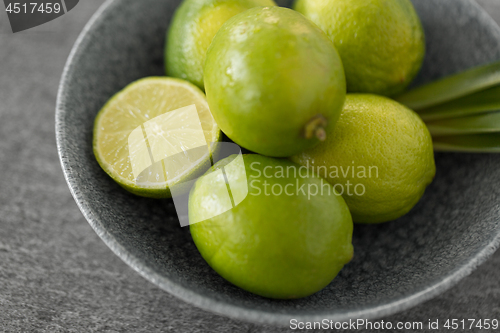 Image of close up of limes in bowl on slate table top