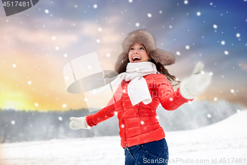 Image of happy woman in fur hat over winter background